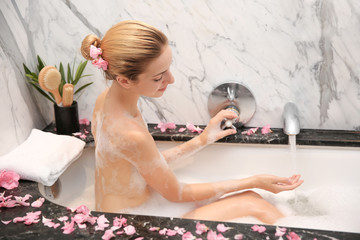 Obraz na płótnie Canvas Young beautiful woman relaxing in bath with foam