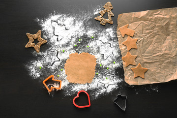 Raw dough and Christmas cookies on table