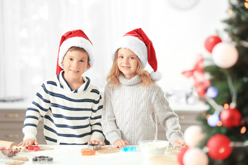 Little children preparing Christmas cookies in kitchen
