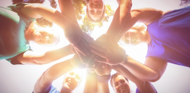 Directly below shot of women stacking hands at camp