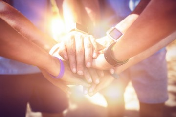 Mid section of athletes forming hands stack