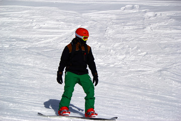 Fototapeta na wymiar Skiers and snowboarders riding on a ski slope in Sochi mountain resort snowy winter