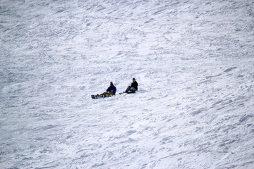 Skiers and snowboarders riding on a ski slope in Sochi mountain resort snowy winter