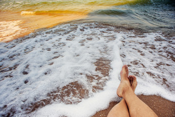 Male legs at the background of surf sea waves