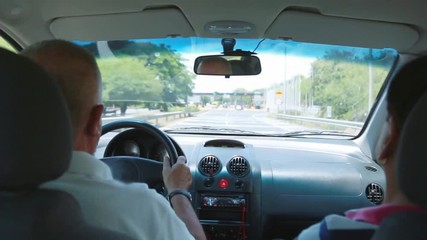 Senior couple driving towards a toll
