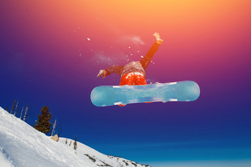 Snowboarder in flight and jumping, shows tricks.