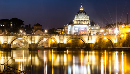 Fototapeta na wymiar Vatican dome and bridge lights mirroed in water