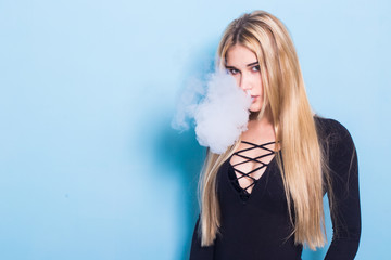 Close-up Portrait of sexy young hipster smoking (vaping) girl. Vapor concept. Vaping e-Cigarette.
