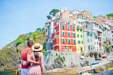 Young family with great view at old village Riomaggiore, Cinque Terre, Liguria, Italy. European italian vacation. - obrazy, fototapety, plakaty