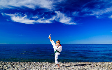 Тренировка мальчика на пляже на море: тхэквондо, спорт