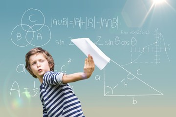 Composite image of playful boy holding paper airplane