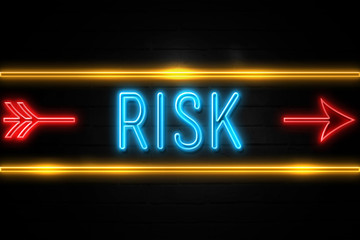 Risk  - fluorescent Neon Sign on brickwall Front view