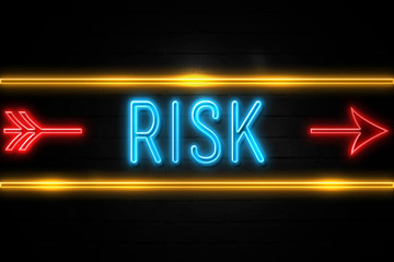 Obraz premium Risk - fluorescent Neon Sign on brickwall Front view