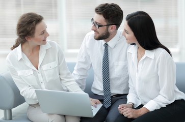 business team looks at the information on the laptop