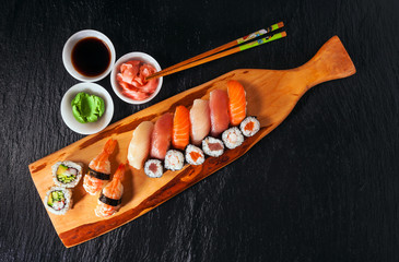 Sushi Set gunkan, nigiri and rolls served on black stone backgro