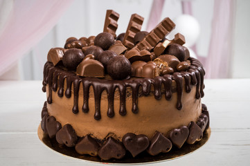 Delicious chocolate cake handmade decorated with chocolate sweets and chocolate bars. Horizontal frame