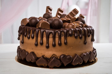 Delicious chocolate cake handmade decorated with chocolate sweets and chocolate bars. Horizontal frame