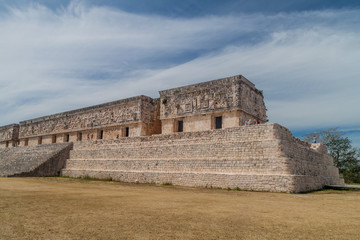 UXMAL, MEXICO - FEB 28, 2016: Tourists visit the ruins of the Palacio del Gobernador (Governor's Palace) building in the ruins of the ancient Mayan city Uxmal, Mexico.