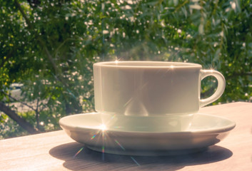 A cup of coffee on a wooden table Against the background of autumn nature