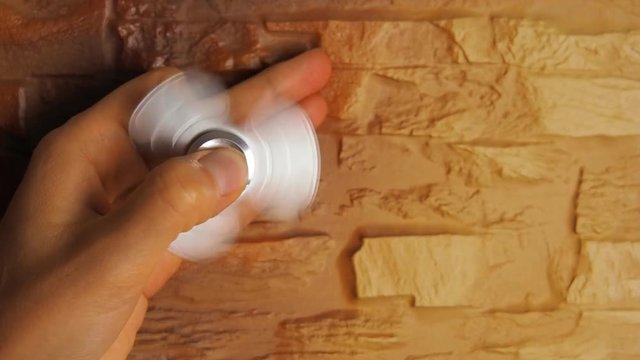 A spinning spiner on a child's hand. The hand of a child with a spinner close up.