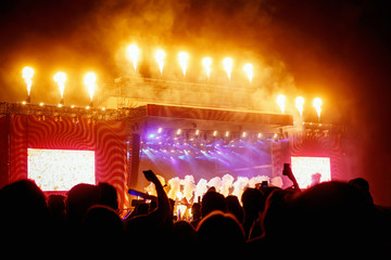 Big concert stage with fire production at outdoor music festival