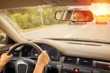 Fototapeta premium Beautiful woman driving a car on the road