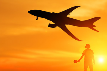 Silhouette of ground staff sending airplane taking off flight