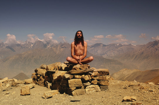 naked wild man meditating in mountains