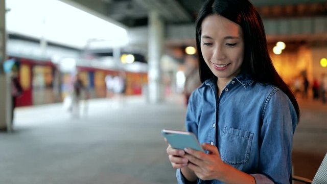 Woman using cellphone in the train platform