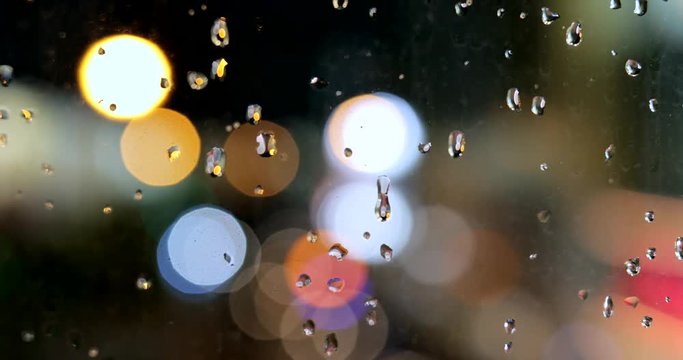 Rain drop on window glass with the cityscape background