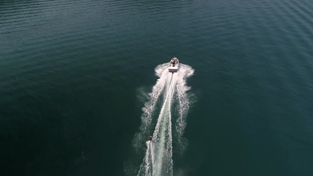 Waterski Aerial of Drone Flying Over Boat Pulling Man on Beautiful Blue Water