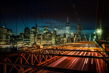 Fototapeta na wymiar Brooklyn Bridge, Downtown Manhattan, New York. Night scene. Light trails. City lights. Urban living and transportation concept