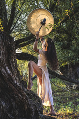 Gypsy woman in the forest drumming