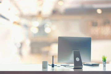 Stylish workspace with desktop computer, office supplies, houseplant and books at home or studio. Blank screen for graphics display montage.
