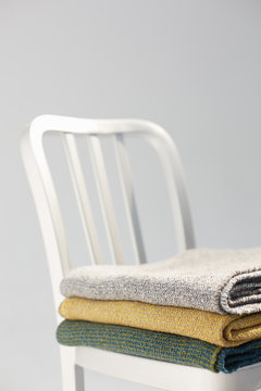 Metallic chair and stack of cotton blankets in the studio