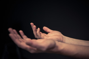 Mens hands reaching out with palms facing up and hands open 