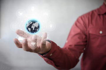 Human hand holding our planet earth glowing with tech icon flow connection concept.
