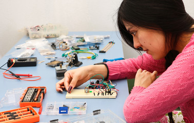 Young electronics student learning about basic PCB connection and robotics