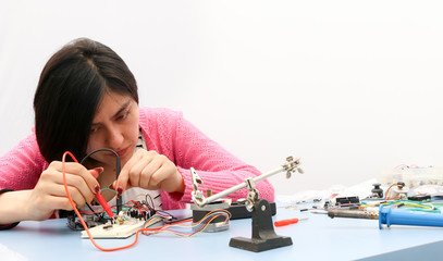 Young electronics student learning about basic PCB connection and robotics