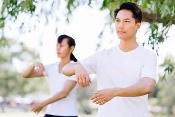 People practicing thai chi in park