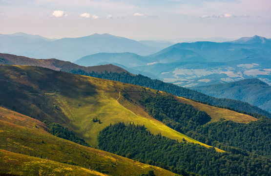 Carpathian Mountains with its peaks, hills, meadows and forests under the blue sky with clouds in late summer day