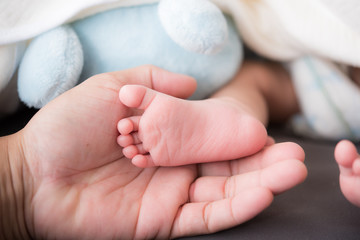 newborn baby feet on male hand