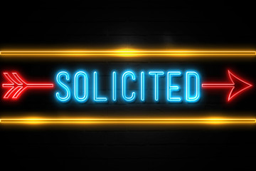 Solicited  - fluorescent Neon Sign on brickwall Front view