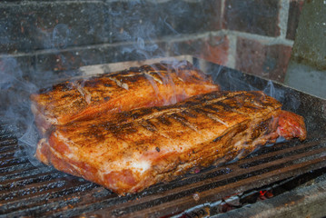 pork ribs marinated grilling and smoking on hot burning charcoal barbecue close-up