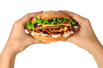 Hands holding a hamburger with lettuce, cheese and bacon on white background.