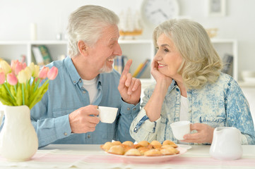 senior couple drinking tea with cookies