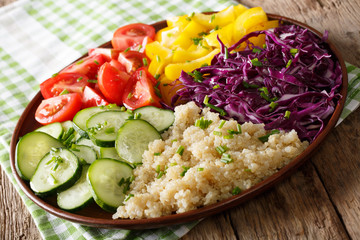 Colorful salad with fresh vegetables and quinoa close up on a plate. horizontal