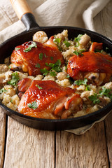 Tasty fried chicken thighs with a movie and mushrooms close-up in a frying pan. vertical
