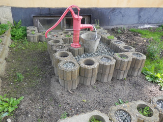 Red hand pump and bucket