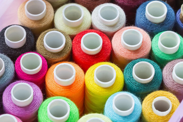 A lot of colorful sewing threads. Abstract background. Selective focus, closeup.